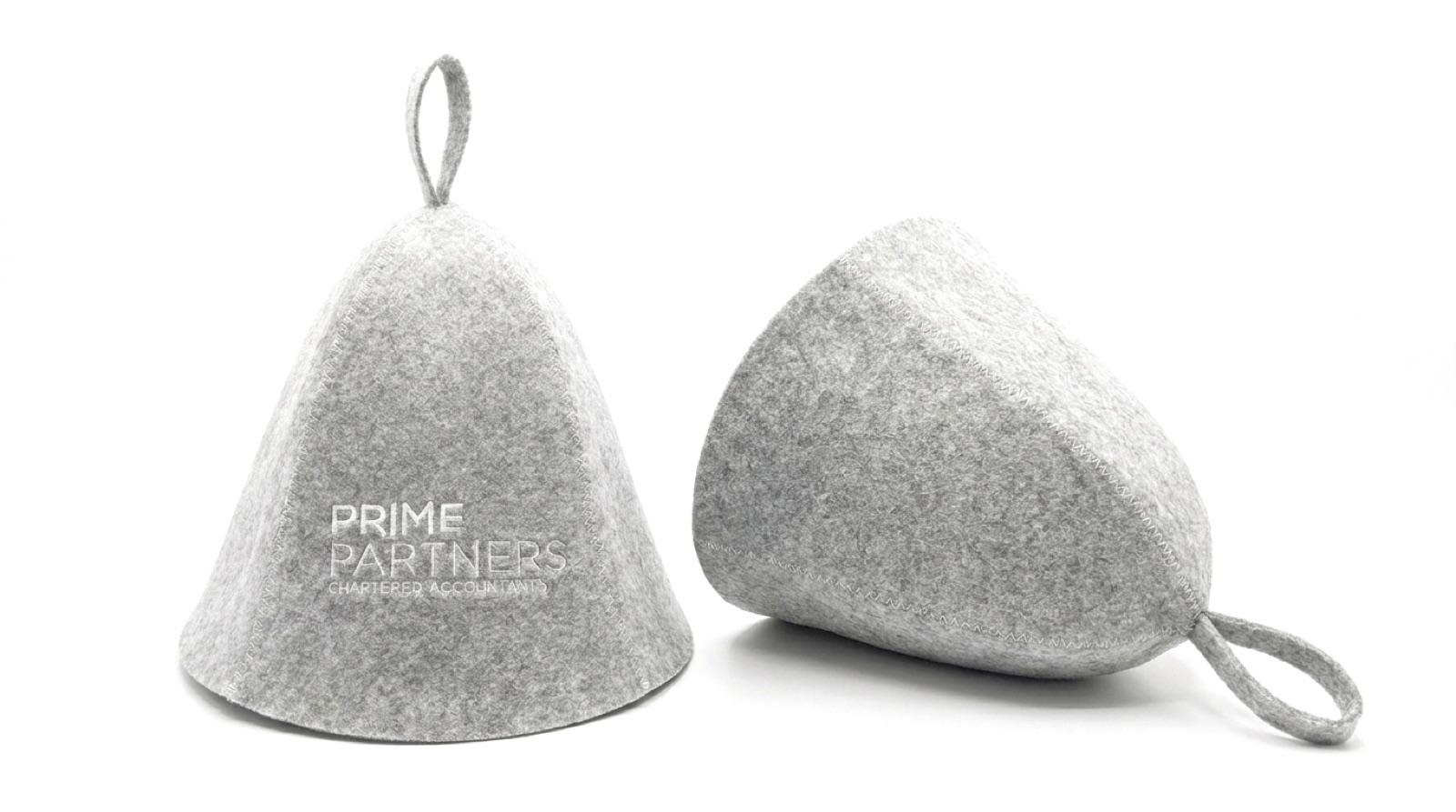 Two identical grey felt sauna hats on a white background, one standing upright and one lying on its side with its hanging loop visible.